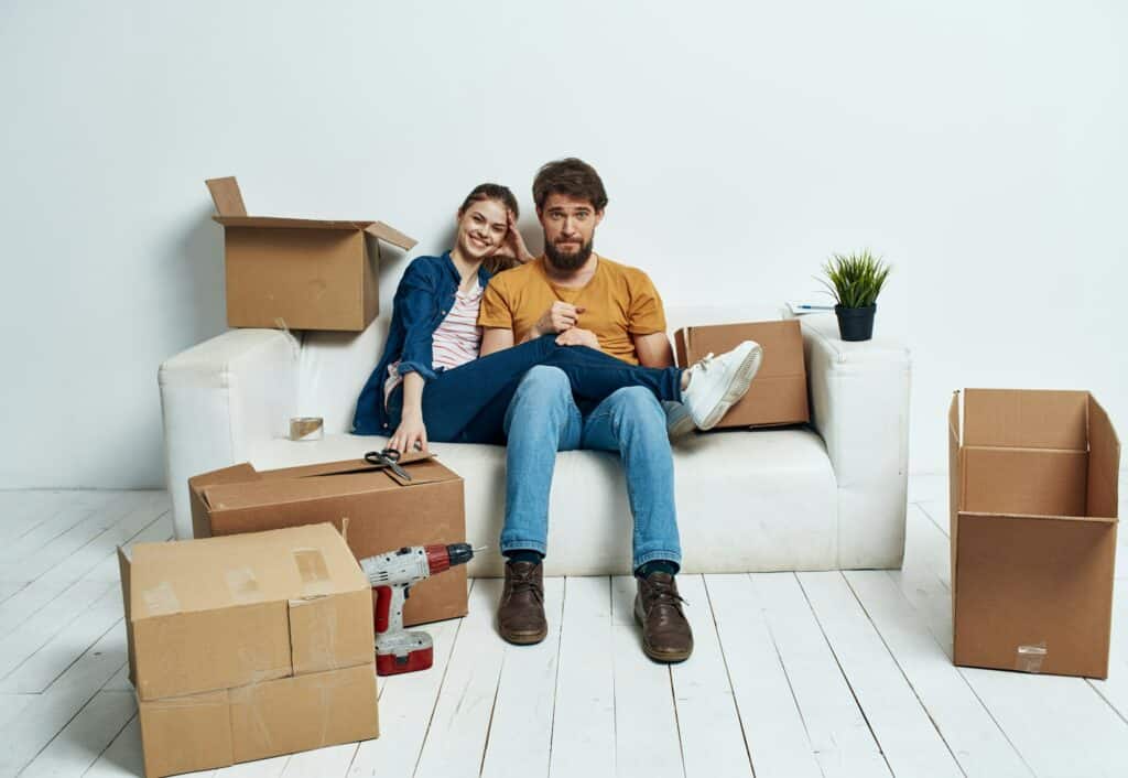 A room on a white sofa with boxes moving apartments