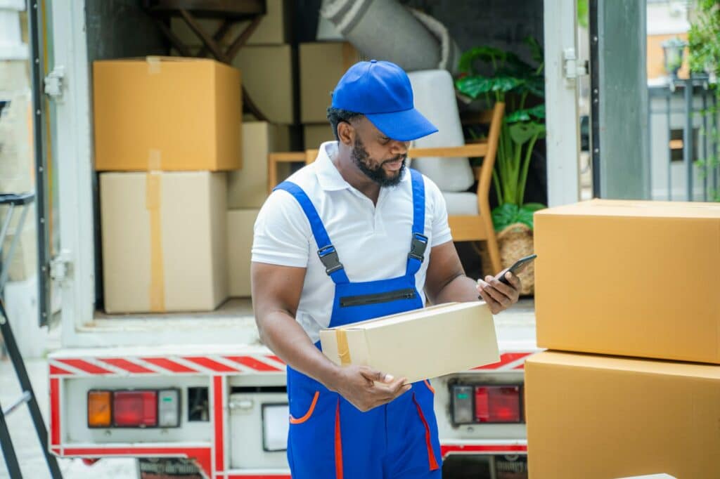 Moving service workers unloading boxes and checking list.