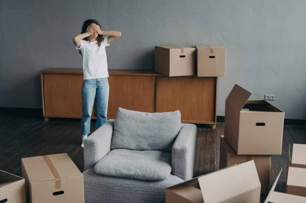 Tired woman surrounded by carton boxes feels stress of relocation. Advertising of moving company